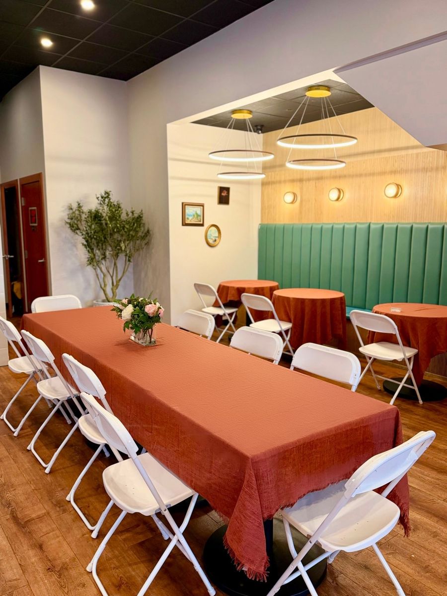 Long table with white chairs and banquette seating